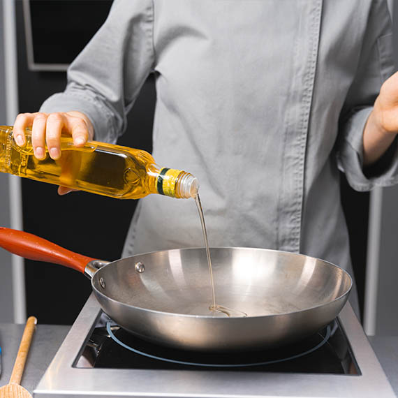 Kuchár pri práci s kuchynským olejom v gastro prevádzke